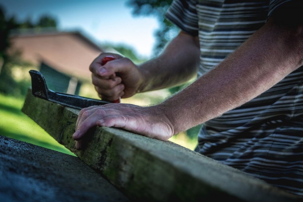 Menuisier qui ddécoupe une planche de bois